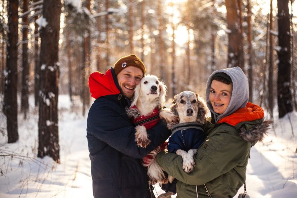 Couple walking their dogs in a winter forest